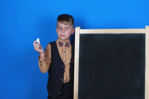 Elegante Colegial Serio Llevando Uniforme Sosteniendo Tiza Mostrando Pizarra Niño — Foto de Stock