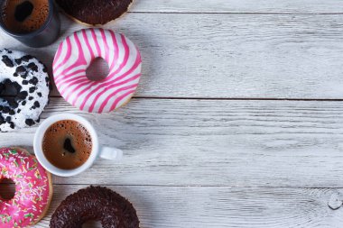 Beyaz ahşap masada çeşitli çörekler ve siyah kahve fincanları. Üst görünüm, boşluğu kopyala. Fırın, kafe menüsü, kahvaltı, mola konsepti