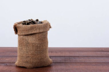 Kahverengi ahşap masada bir çuval ayçekirdeği. Yan görüş, yakın çekim, kopyalama alanı. Gıda, hasat, tarım, tarım kavramı