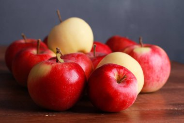 Kahverengi ahşap masada kırmızı ve beyaz elma yığını. Yakından bak. Doğal organik gıda, sağlıklı beslenme, hasat mevsimi konsepti