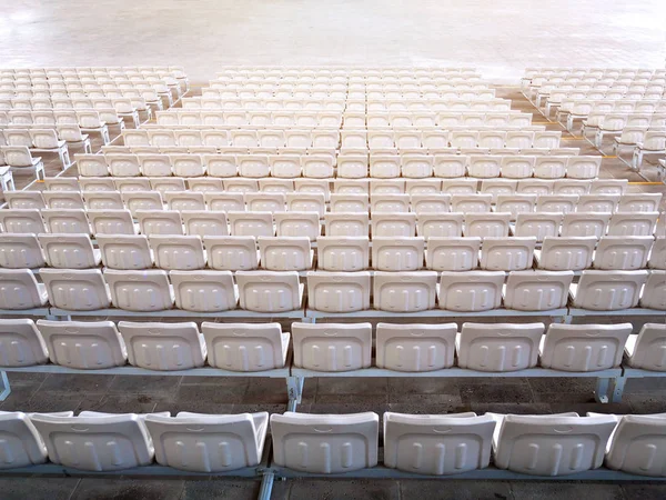 Empty stadium seats in row viewed from behind.