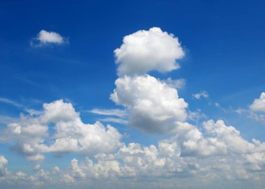 Cumulus bulutları mavi gökyüzü arka planda.