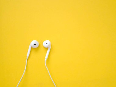 Sarı arka planda beyaz kulaklıklar