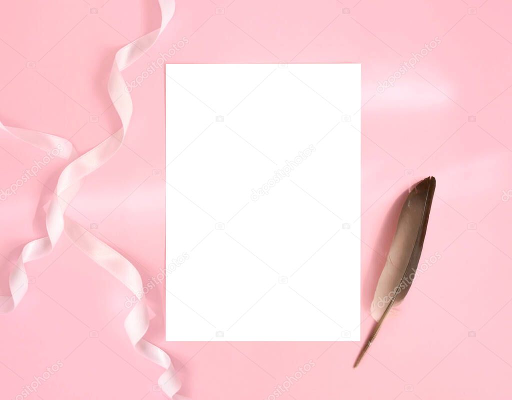 Blank white card mockup with feather and ribbon on pink background