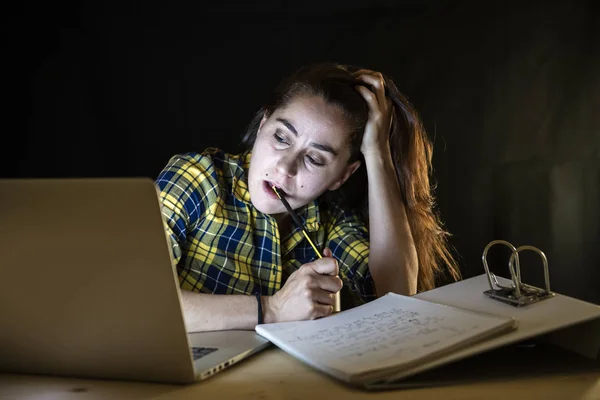 過労の女子大学生の頭を押しながら眠りに落ちるようにしてラップトップに取り組んで格子縞のシャツ — ストック写真