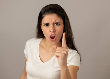 Kızgın bir yüz çekici bir genç latin kadın portresi kapatın. öfkeli ve deli diş gösterme ve kameraya parmak işaret arıyorum. İnsan yüz ifadeleri ve duygular
