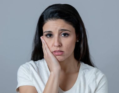 Güzel bir genç latin Latin asıllı kadın depresif bir yüz ile portresi kapatın. sefil, melankoli ve üzgün bakıyor. İnsan yüz ifadeleri ve duygular kavramı. Gri arka plan