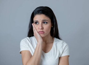 Güzel bir genç latin Latin asıllı kadın depresif bir yüz ile portresi kapatın. sefil, melankoli ve üzgün bakıyor. İnsan yüz ifadeleri ve duygular kavramı. Gri arka plan