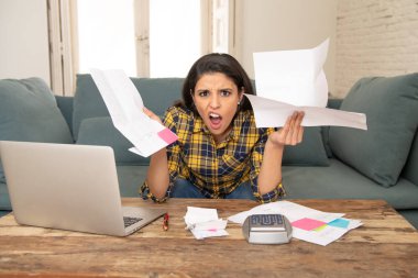 Genç çekici kadın endişeli bankacılık ve evrak işlerini yaparken bilgisayar dizüstü bilgisayar ile ev ve kredi kartı harcamaları muhasebe maliyet stres yaşayan ve faturaları sorun ödeme evde