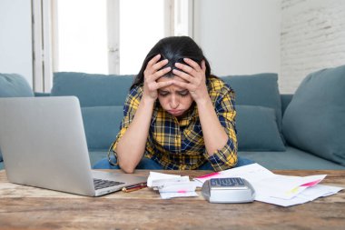 Genç çekici kadın endişeli bankacılık ve evrak işlerini yaparken bilgisayar dizüstü bilgisayar ile ev ve kredi kartı harcamaları muhasebe maliyet stres yaşayan ve faturaları sorun ödeme evde
