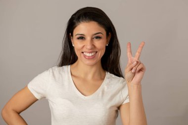 Mutlu bir yüz ile güzel genç latin Latin asıllı kadın kapatın. Güzel bir gülümseme ve zafer bir jest. Olumlu insan yüz ifadeleri