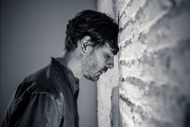 depresif adam kadar evde, karanlık odada beyaz duvara yaslanmış mutsuz, yorgun ve bir ruh sağlığı depresyon kavramı endişeli duygu.