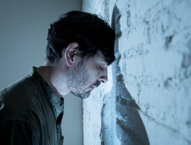 depresif adam kadar evde, karanlık odada beyaz duvara yaslanmış mutsuz, yorgun ve bir ruh sağlığı depresyon kavramı endişeli duygu.