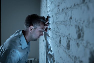 depresif adam kadar evde, karanlık odada beyaz duvara yaslanmış mutsuz, yorgun ve bir ruh sağlığı depresyon kavramı endişeli duygu.