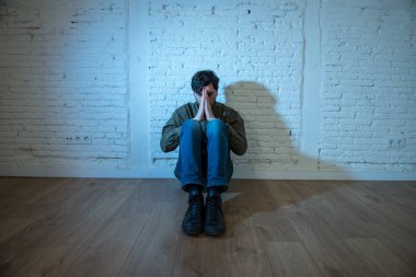 sefil, yalnız ve üzgün ruh sağlığı depresyon kavramı içinde duygu duvardaki bir gölge ile beyaz bir duvar karşı evde oturan genç depresif adam