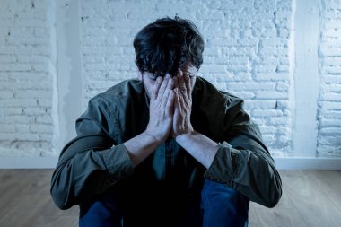 sefil, yalnız ve üzgün ruh sağlığı depresyon kavramı içinde duygu duvardaki bir gölge ile beyaz bir duvar karşı evde oturan genç depresif adam