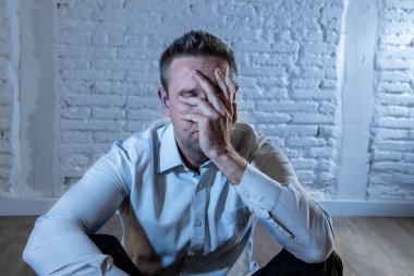 üzgün, yalnız ve ruh sağlığı depresyon kavramı içinde evde beyaz bir duvara yaslanmış anksiyete acı duygu depresif iş adamı