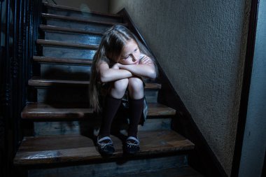 Üzgün, depresif, mutsuz kız öğrenci zorbalık ve duygu yalnız ve umutsuz karanlık ışık ile merdivenlerde oturan kötüye acı. Okul yalıtım, zorbalık, taciz ve istismar kavramı