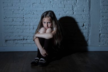 Bulling ve yalnız, mutsuz umutsuz ve umutsuz oturma duvara karanlık ışık felling taciz acı üzgün çaresiz genç kızı. Okul yalıtım, şiddet ve zorbalık kavramı