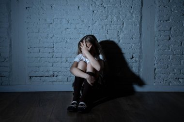 Bulling ve yalnız, mutsuz umutsuz ve umutsuz oturma duvara karanlık ışık felling taciz acı üzgün çaresiz genç kızı. Okul yalıtım, şiddet ve zorbalık kavramı