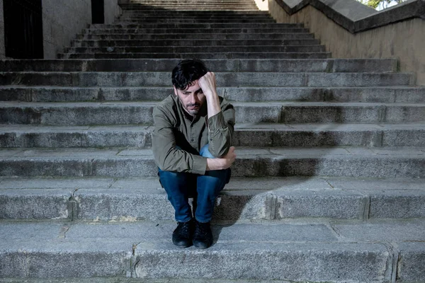 latin man stressed from work sitting on steps outside feeling anxiety in adult cause of depression and problem in living that makes you feel lonely, sad and worried in mental health concept