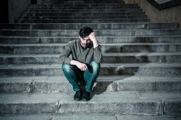 latin man stressed from work sitting on steps outside feeling anxiety in adult cause of depression and problem in living that makes you feel lonely, sad and worried in mental health concept