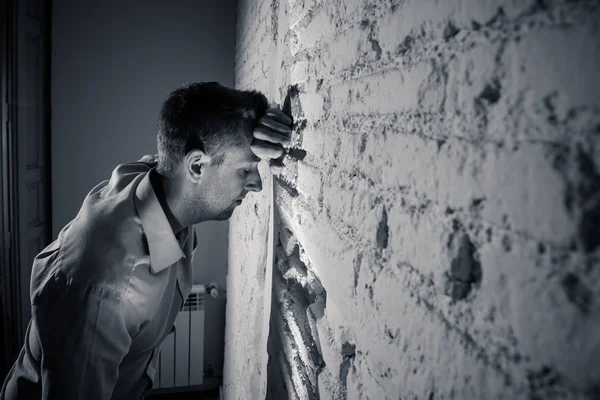Депрессивный Человек Опираясь Белую Стену Темной Комнате Дома Чувствуя Грусть — стоковое фото