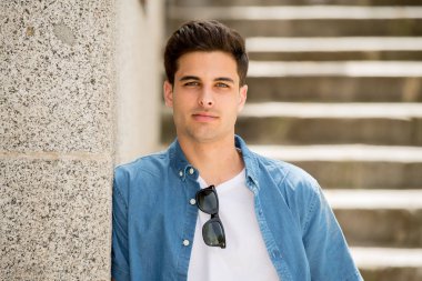 Modern trendy İspanyol yakışıklı genç City açık portresi. Kentsel arka plan