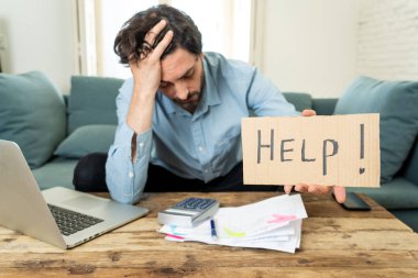 Laptop ile evde çalışma, sinirli ve endişeli genç adam bir yardım işareti faturaları seyir ve ev finansman kavramında fatura ödeme holding