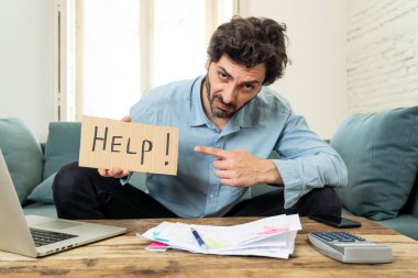 Laptop ile evde çalışma, sinirli ve endişeli genç adam bir yardım işareti faturaları seyir ve ev finansman kavramında fatura ödeme holding