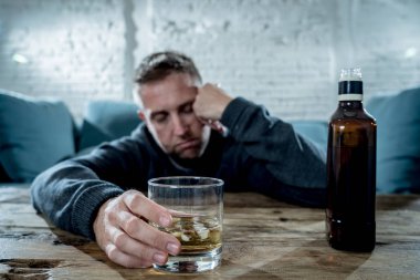 Sarhoş alkolik işsiz içme viski cam adam ve şişe alkol kötüye kullanımı ve alkolizm Konsept ev koltukta israf ve üzgün, depresif