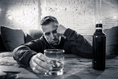 Sarhoş alkolik işsiz içme viski cam adam ve şişe alkol kötüye kullanımı ve alkolizm Konsept ev koltukta israf ve üzgün, depresif
