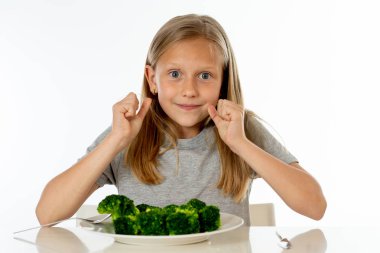 Onun brokoli sebze yeme mutlu genç sarışın kız. sağlıklı çocuk beslenme kavramı