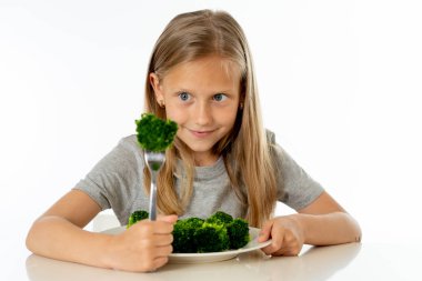 Onun brokoli sebze yeme mutlu genç sarışın kız. sağlıklı çocuk beslenme kavramı
