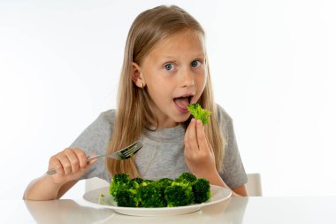 Onun brokoli sebze yeme mutlu genç sarışın kız. sağlıklı çocuk beslenme kavramı