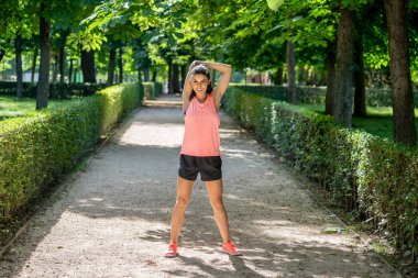 Daha önce fitness antrenman fitness sağlık kavramı vücudu germe içinde açık havada kadar ısınma Gölü sağlıklı genç bir kadın ile parkta genç çekici latin kadın egzersiz.