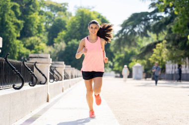 çalışan ve ağaçlar ve sarı yapraklar Şehir Park açık havada koşu eğitim sonbahar spor giyim kadın genç çekici ve mutlu atlet. Fitness ve sağlıklı yaşam konsepti