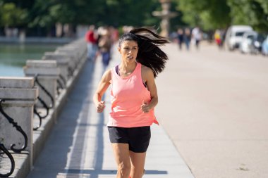 Güneşli parlak ışık kadın fitness modeli eğitim dışında şehir yeşil park geçiş eğitim fitness egzersiz kavramı içinde koşu acı çalışan kadın runner