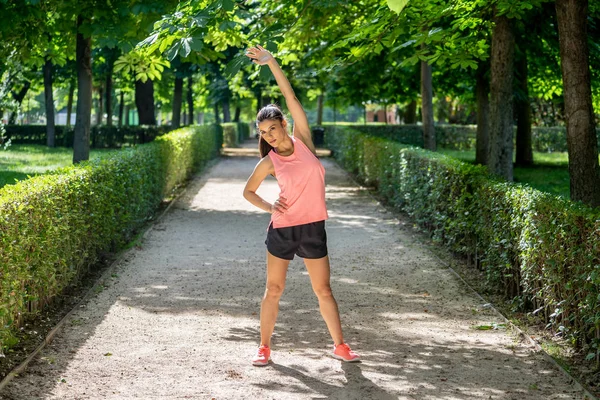 Daha önce fitness antrenman fitness sağlık kavramı vücudu germe içinde açık havada kadar ısınma Gölü sağlıklı genç bir kadın ile parkta genç çekici latin kadın egzersiz.