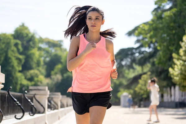 Güneşli parlak ışık kadın fitness modeli eğitim dışında şehir yeşil park geçiş eğitim fitness egzersiz kavramı içinde koşu acı çalışan kadın runner