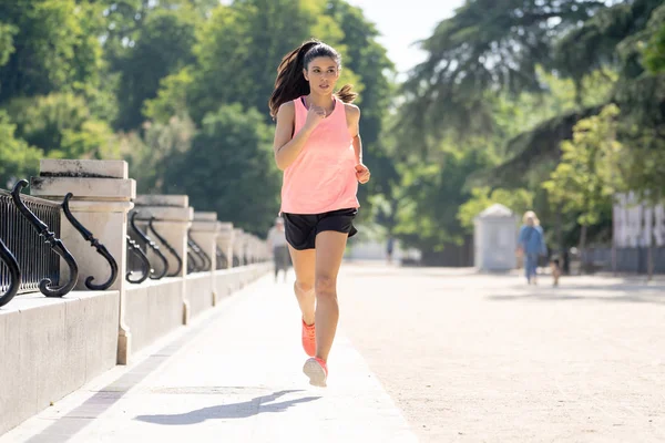 Güneşli parlak ışık kadın fitness modeli eğitim dışında şehir yeşil park geçiş eğitim fitness egzersiz kavramı içinde koşu acı çalışan kadın runner