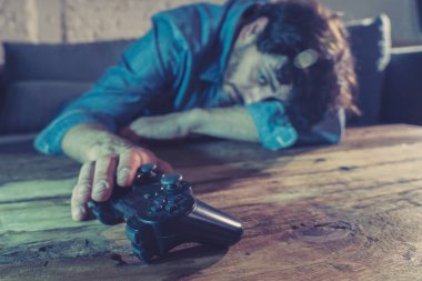 Bağımlılık ve bağımlılık kavramı. iskambil video spor erkek konsol oyun kavramı için bağımlısı pad joystick ile genç adam yakın çekim.