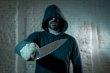 elinde bir bıçakla tehlikeli kukuletalı adam ayakta karanlıkta el kapatın. Londra bıçak suç kavramı.