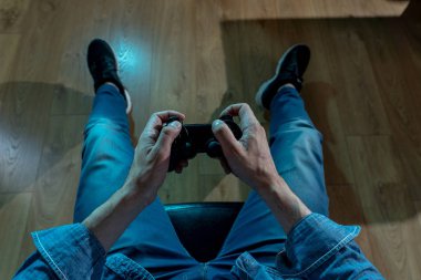 Bağımlılık ve bağımlılık kavramı. Genç adamın elleri üzerinde video oyunları oynarken pad joystick ile kapatın. Konsol oyun kavramı için bağımlısı erkek.