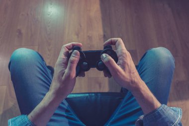 Bağımlılık ve bağımlılık kavramı. Genç adamın elleri üzerinde video oyunları oynarken pad joystick ile kapatın. Konsol oyun kavramı için bağımlısı erkek.