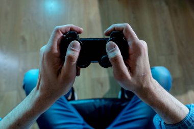 Bağımlılık ve bağımlılık kavramı. Genç adamın elleri üzerinde video oyunları oynarken pad joystick ile kapatın. Konsol oyun kavramı için bağımlısı erkek.