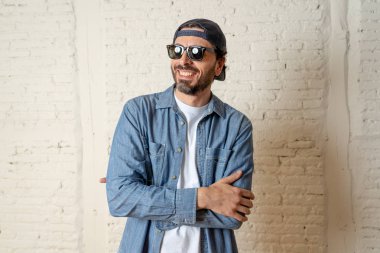 genç çekici hippi, trendy tarzı rahat şapka gayrı giyinme tutum ile mutlu poz serin gülümseyen adam arıyorum. Erkek moda kavramı.