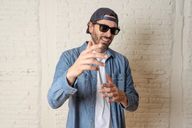 genç çekici hippi, trendy tarzı rahat şapka gayrı giyinme tutum ile mutlu poz serin gülümseyen adam arıyorum. Erkek moda kavramı.