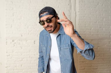 genç çekici hippi, trendy tarzı rahat şapka gayrı giyinme tutum ile mutlu poz serin gülümseyen adam arıyorum. Erkek moda kavramı.