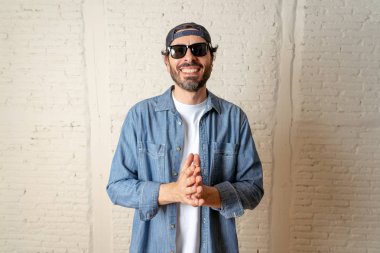 genç çekici hippi, trendy tarzı rahat şapka gayrı giyinme tutum ile mutlu poz serin gülümseyen adam arıyorum. Erkek moda kavramı.